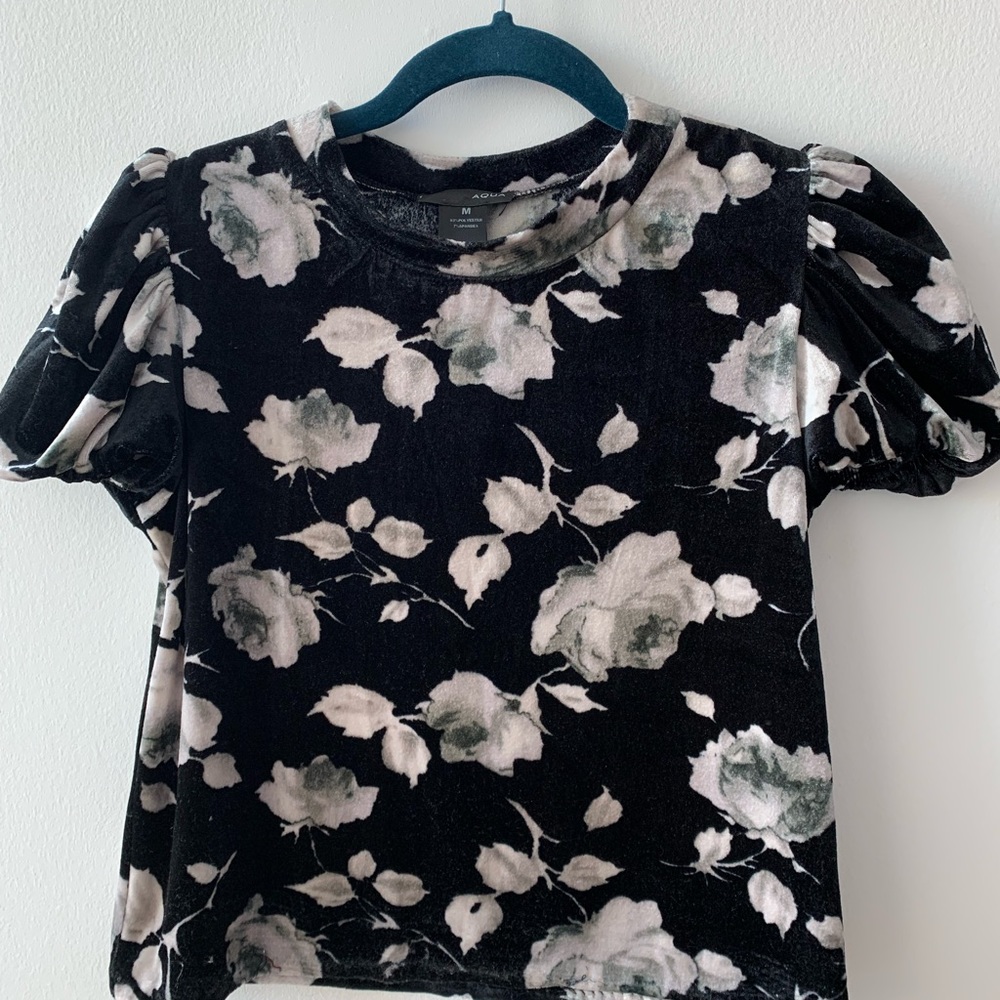 A black floral top, its size is M but fits an S person pretty well.